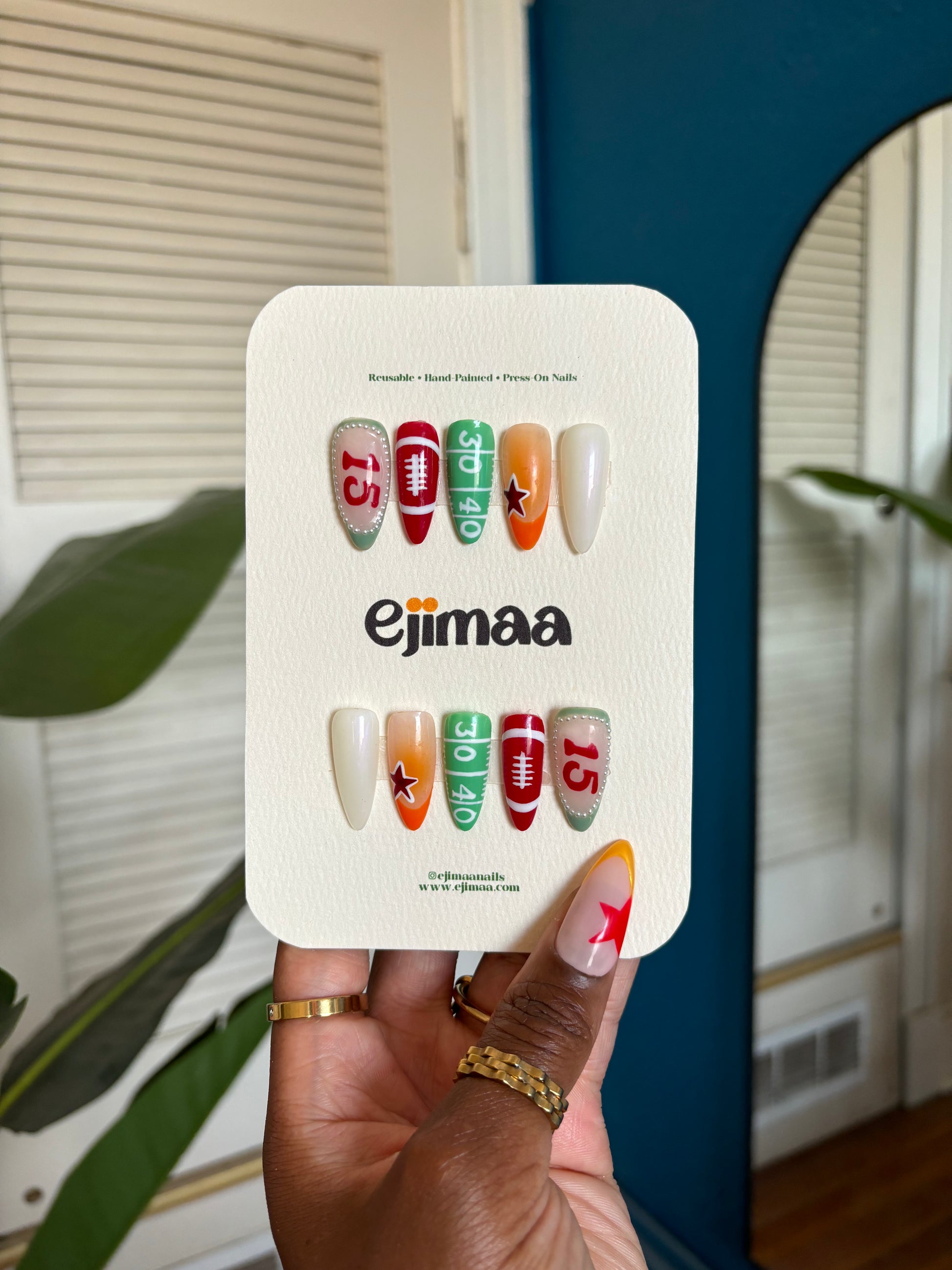 Hand holding a nail art kit with 'ejimaa' branding against a neutral background