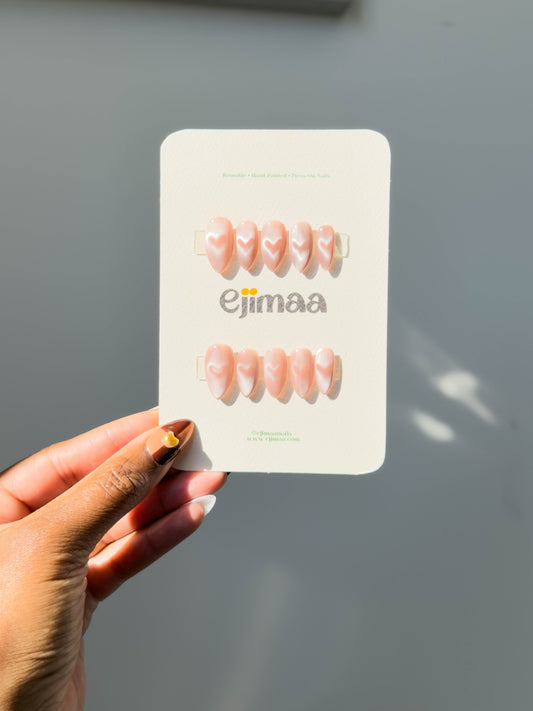 Hand holding a nail card with 'ejimaa' branding against a neutral background